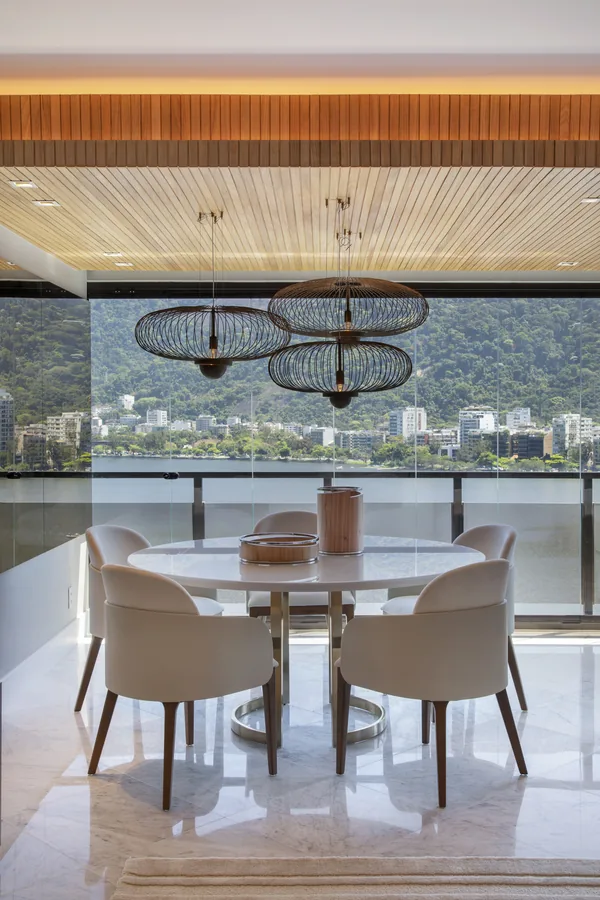 Mesa de jantar redonda junto à varanda, com vista para a Lagoa
