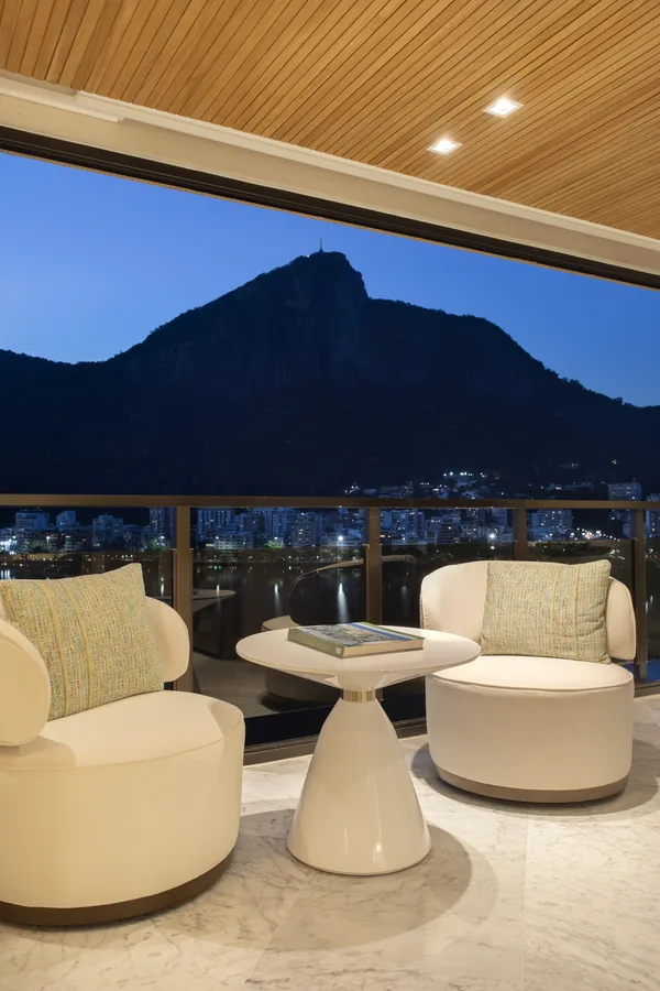 Varanda à noite, com poltronas e vista para as montanhas