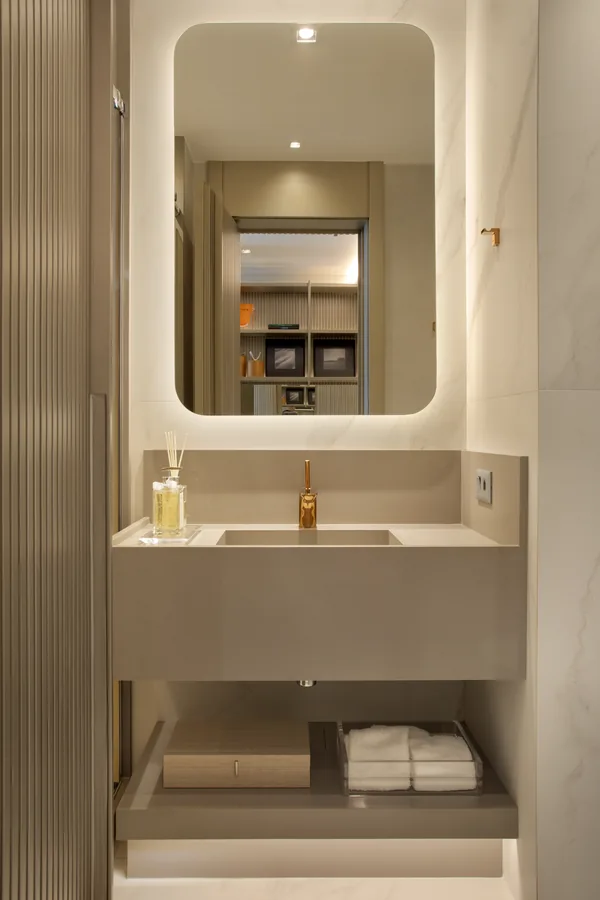 Lavabo com cuba em pedra e espelho com iluminação