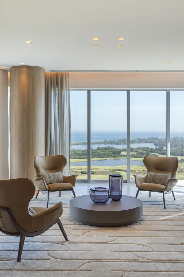 Estar com poltronas e vista panorâmica pela janela