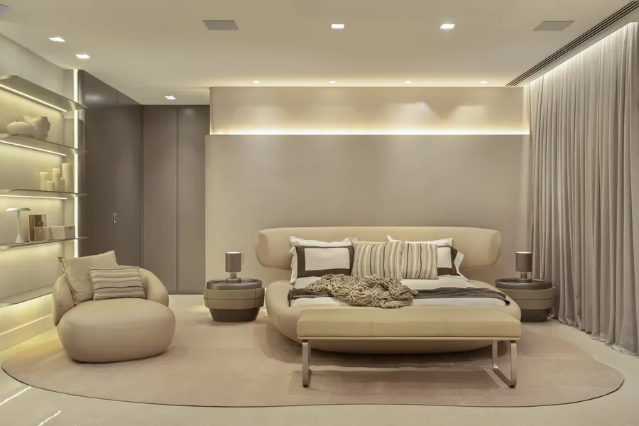 Suíte com cama estofada, nichos iluminados e tapete orgânico