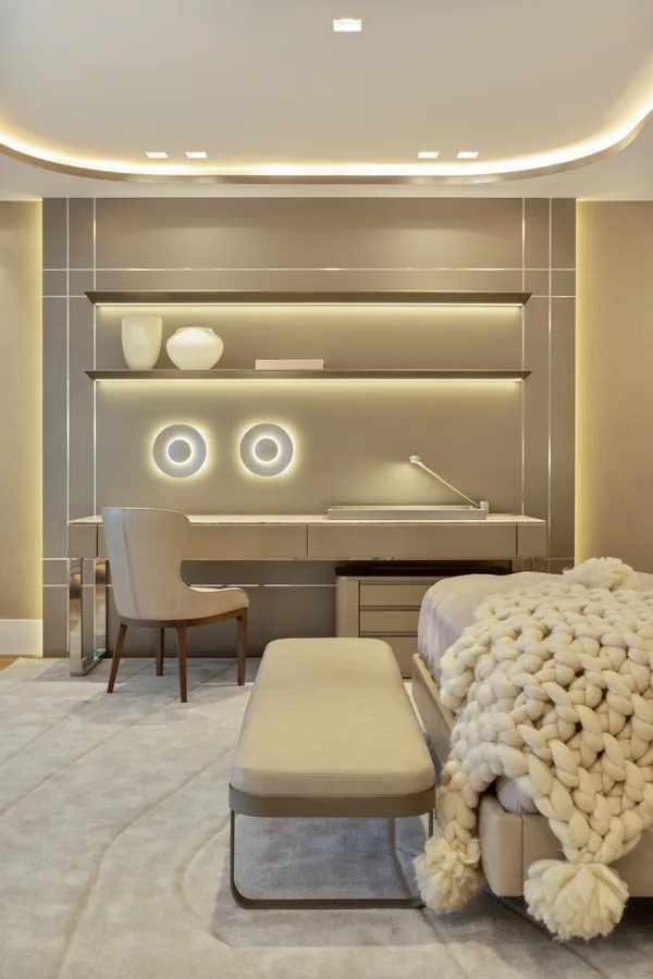 Quarto com painel em laca, bancada de trabalho, prateleiras iluminadas e arandelas