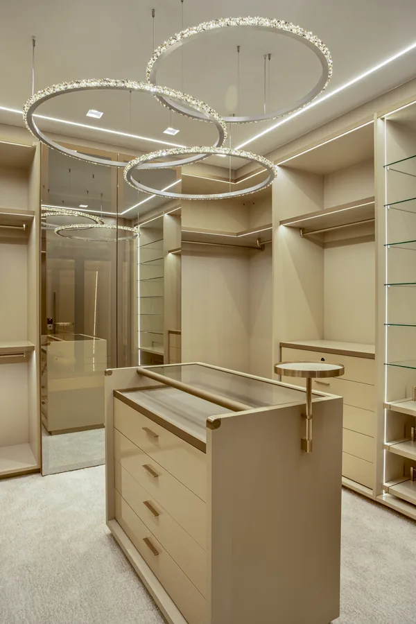 Closet com ilha central, vitrines e lustre de anéis